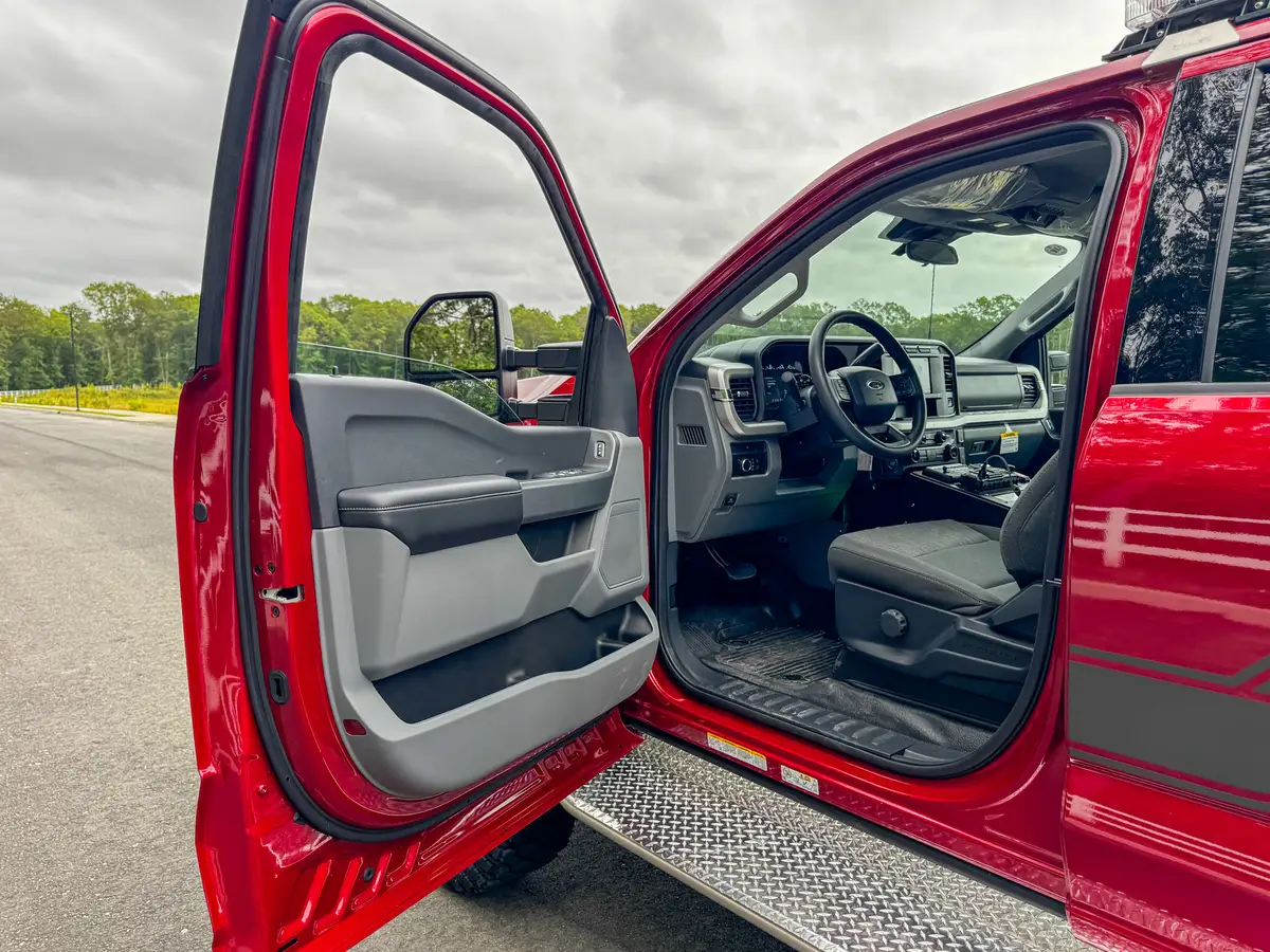 Driver cockpit view with steering wheel, gauge cluster, and center controls.